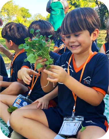 Criança segurando uma planta.